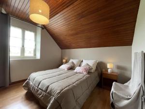 a bedroom with a large bed with a wooden ceiling at Chez lilles in Arette