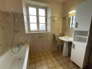 a bathroom with a tub and a sink at Chez lilles in Arette +23 photos