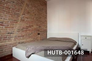 uma cama num quarto com uma parede de tijolos em Ghat Apartment Poble Sec Barcelona em Barcelona