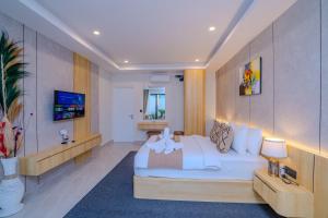 a bedroom with a white bed and a tv at Sanara Oasis Villa in Canggu