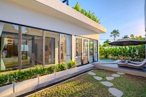 a house with a patio and an umbrella at Sanara Oasis Villa in Canggu