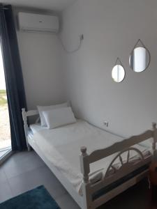 a white bed with two lights on top of it at Dinos Apartments in Ulcinj
