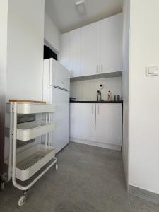 a kitchen with white cabinets and a white refrigerator at Apartman na Drini in Loznica