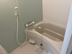 a small bathroom with a toilet and a bath tub at ビジネスホテルinn in Kashima