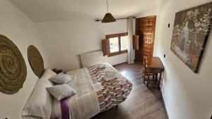 a bedroom with a bed and a table and a desk at Hostal Altajo con Restaurante, Naturaleza & Descanso en el Alto Tajo in Peralejos de las Truchas