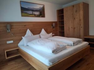 a bedroom with a bed with white sheets and pillows at Gästehaus Zunterer in Wallgau