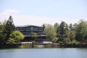 a large house sitting on the side of a lake at ホテルグランリゾート蓼科 in Chino