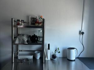 a shelf with dishes and other items in a room at The Orbit Retreat in Kampong Bunut
