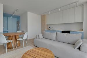 a living room with a white couch and a table at GRANO FLATS Trimare Sztutowo in Sztutowo