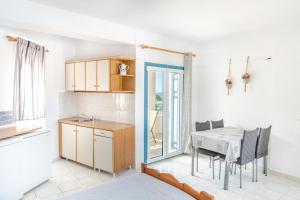 a kitchen and dining room with a table and chairs at Fiore Di Mare Studios in Lassi