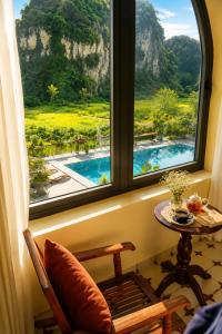 a window with a view of a pool and a table at Tam Cốc AppA House in Ninh Binh