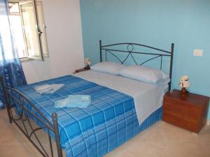 una camera da letto con un letto con un piumone blu di B&B Porta di Suso Camerota a Camerota