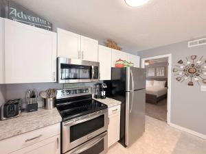 a kitchen with a stove and a refrigerator at Lakefront Vibes Waterfront Pool in Osage Beach