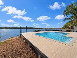 a swimming pool on a dock next to a body of water at Lakefront Vibes Waterfront Pool in Osage Beach