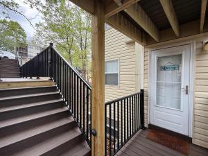 a staircase leading to a house with a white door at Lakefront Vibes Waterfront Pool in Osage Beach