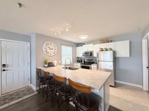 a kitchen with a large island with bar stools at Lakefront Vibes Waterfront Pool in Osage Beach