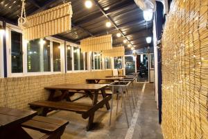 a row of wooden tables in a restaurant with windows at Daecheon gyeoulyeonga pension in Boryeong