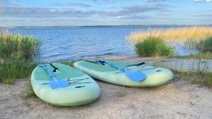 two kayaks sitting on the shore of a body of water at Wunderhaus am Goitzschesee in Bitterfeld