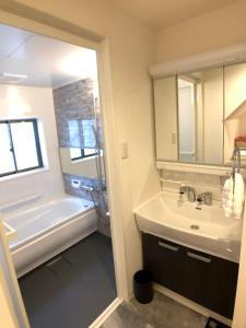 a bathroom with a sink and a bath tub at Nagoya Minpaku, KANAYAMA BASE in Mutsunochō