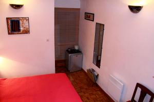 1 dormitorio con cama roja y 1 dormitorio con mesa en Chambre d'Hôtes la Poterie, en Caunes-Minervois