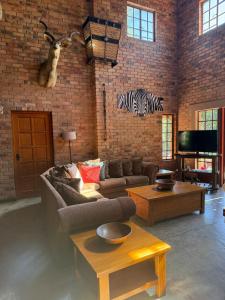 a living room with a couch and a zebra on the wall at Bush and Gables in Marloth Park