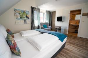 ein Schlafzimmer mit einem weißen Bett und einem Stuhl in der Unterkunft Hotel Volapük in Konstanz + 30 Fotos