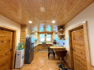 a kitchen with wooden floors and a wooden ceiling at Oak & Amber Retreat in Manāli