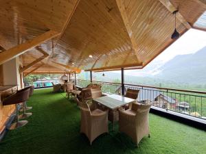 a restaurant with a table and chairs on a balcony at Oak & Amber Retreat in Manāli