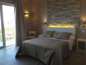 a bedroom with a bed and a brick wall at Borgo di Santa Barbara in Santa Domenica
