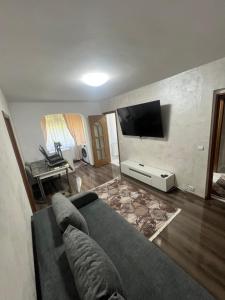 a living room with a couch and a flat screen tv at Apartamente Giu in Giurgiu