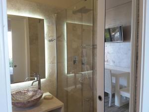 a bathroom with a glass shower and a sink at Borgo di Santa Barbara in Santa Domenica