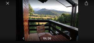 a balcony with a bench and a view of mountains at cosy forest chalet in Râşnov