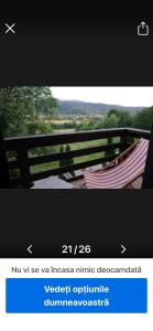 a picture of two hammocks on a deck with a fence at cosy forest chalet in Râşnov