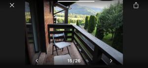 a balcony of a house with a chair on it at cosy forest chalet in Râşnov +2 photos