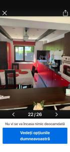 a kitchen with red cabinets and a table in a room at cosy forest chalet in Râşnov