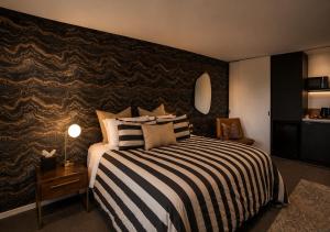 a bedroom with a bed with a black and white striped blanket at Cathedral Junction Apartments in Christchurch