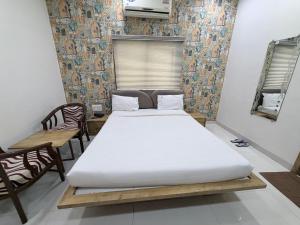 a bedroom with a bed and a table and chairs at Hotel SR Executive, Akola in Akola