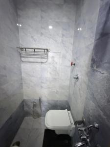 a bathroom with a white toilet and a shower at Hotel SR Executive, Akola in Akola