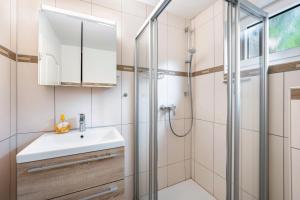 a bathroom with a sink and a shower at Haus am See in Stocksee +37 photos
