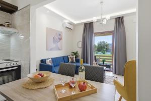 a kitchen and living room with a table with wine glasses at Villa Astron in Agios Georgios