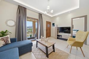 a living room with a blue couch and a table at Villa Astron in Agios Georgios