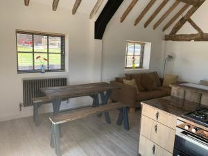 a kitchen and living room with a table and a couch at 3 or 4 Bed 2 Bath Cosy Rural Barn Conversion-Parking in Beoley