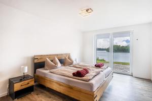 a bedroom with a large bed with a large window at Haus am See in Stocksee