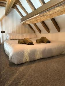 a large white bed in a room with wooden ceilings at 3 or 4 Bed 2 Bath Cosy Rural Barn Conversion-Parking in Beoley