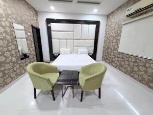 a dining room with a table and two chairs at Hotel SR Executive, Akola in Akola +17 photos