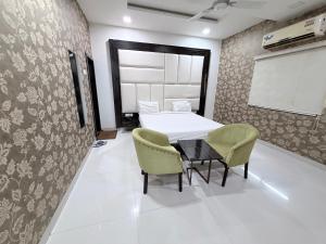 a room with a bed and a table and chairs at Hotel SR Executive, Akola in Akola