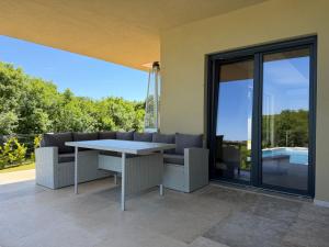 a patio with a table and chairs on a balcony at Villa Nella in Tinjan