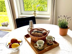 a basket of fruit and a bottle of wine on a table at Ruhe-Natur-Meerblick-Das-Atelier-in-Lohme-Wandern-Radfahren-Golf-direkt-vor-der-Tuer in Lohme