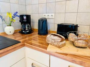 a kitchen counter with bread and a toaster on a counter at Ruhe-Natur-Meerblick-Das-Atelier-in-Lohme-Wandern-Radfahren-Golf-direkt-vor-der-Tuer in Lohme