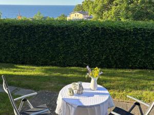 a white table with a vase of flowers on it at Ruhe-Natur-Meerblick-Das-Atelier-in-Lohme-Wandern-Radfahren-Golf-direkt-vor-der-Tuer in Lohme +12 photos